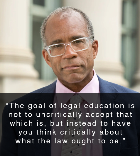 Man posed in front of building smiling with quote that reads, "The goal of legal education is not to uncritically accept that which is, but instead to have you think critically about what the law ought to be."